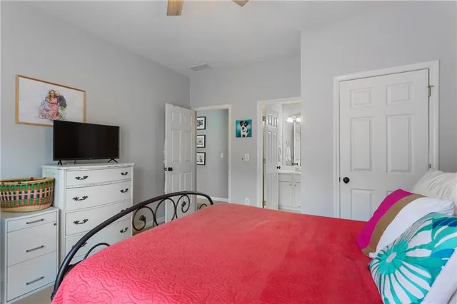 a bedroom with a bed and a flat screen tv in white walls