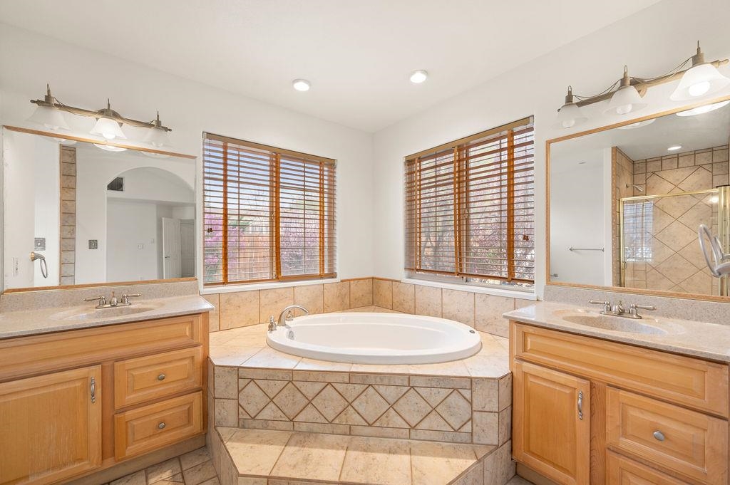 2285 Vista Rio Court Grand Junction, CO 81507 - Photo 12 of 34 a spacious bathroom with a granite countertop sink mirror and a bathtub