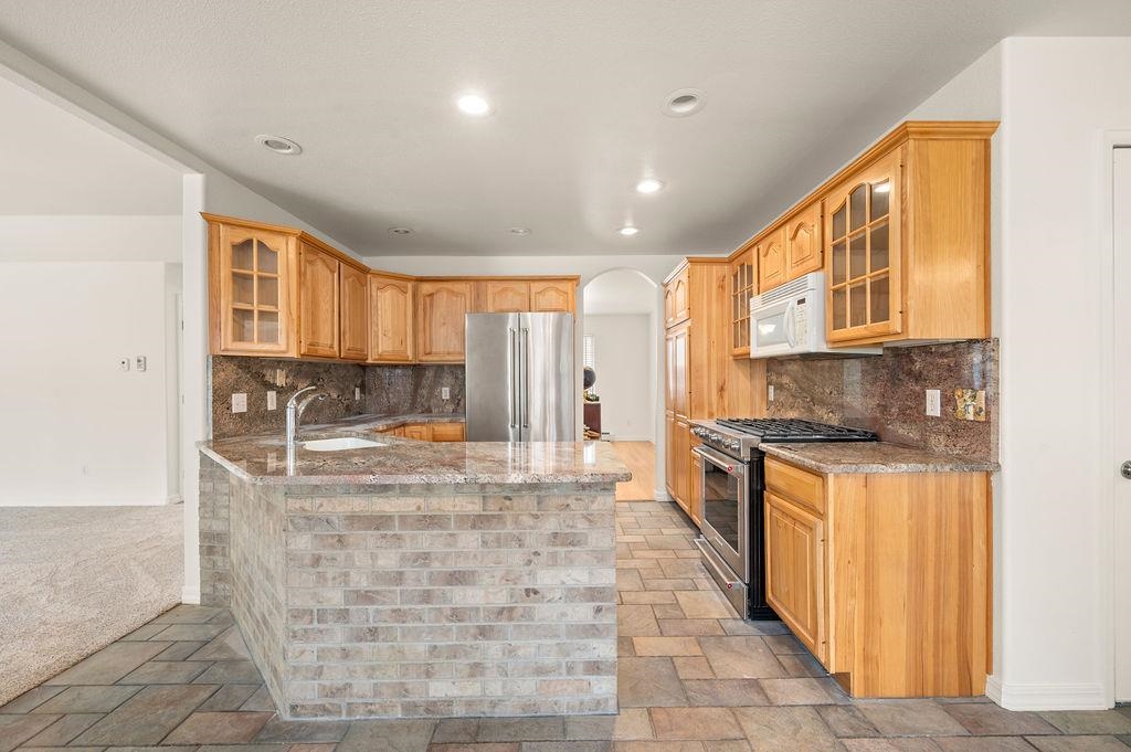 2285 Vista Rio Court Grand Junction, CO 81507 - Photo 27 of 34 a large kitchen with stainless steel appliances granite countertop a stove and a sink