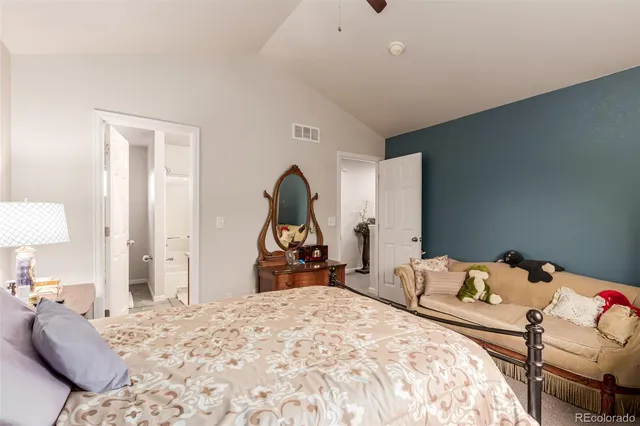 a bedroom with a bed and a mirror on dresser