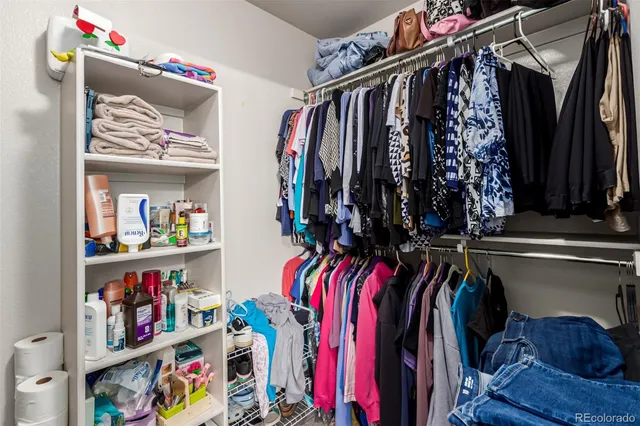 a view of walk in closet with clothes and shoes