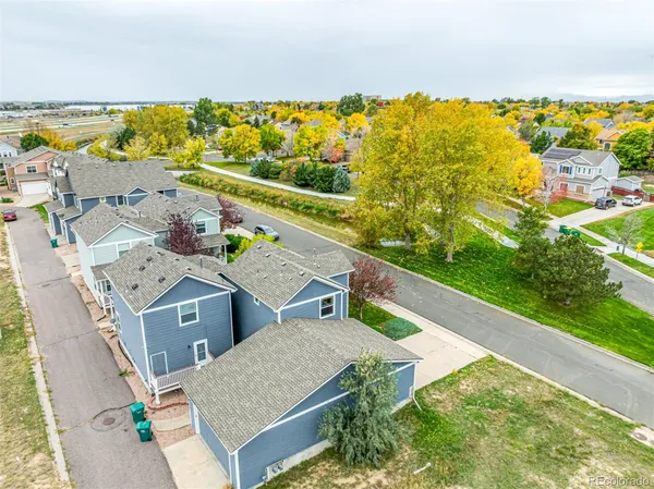an aerial view of residential houses with outdoor space and ocean view