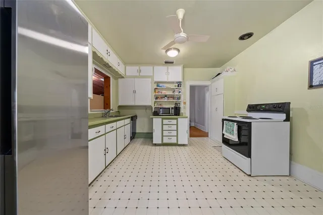 a kitchen with stainless steel appliances kitchen island granite countertop a refrigerator and a stove top oven
