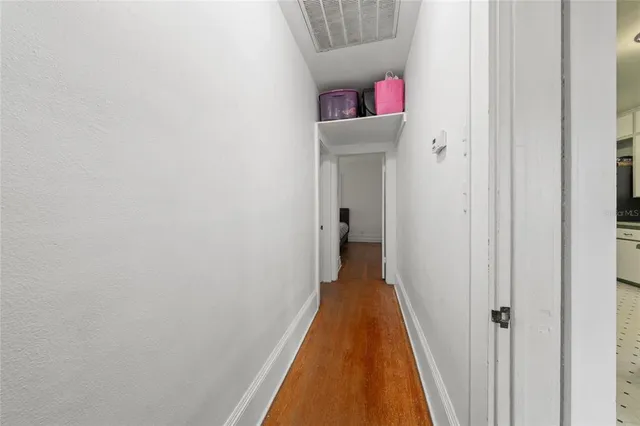 a hallway with front door wooden floor and closet
