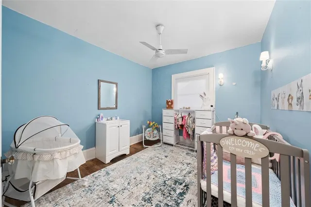 a bedroom with furniture a baby crib and a wooden floor