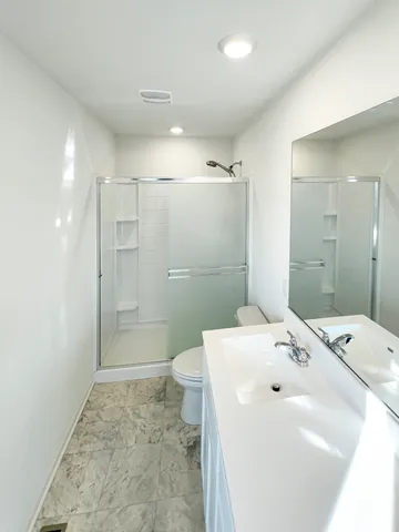 a bathroom with a sink a toilet and shower