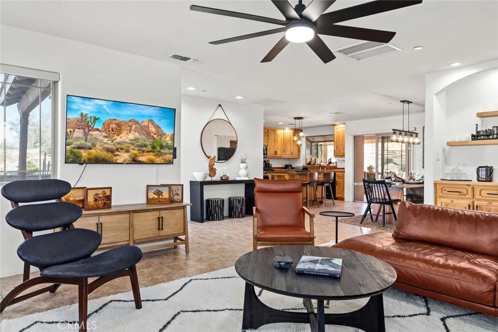 7030 Mile Square Road Joshua Tree, CA 92252 - Photo 13 of 58 a living room with furniture a rug and a chandelier