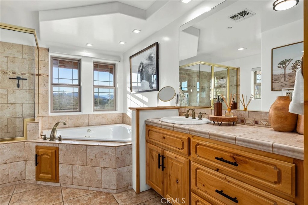 7030 Mile Square Road Joshua Tree, CA 92252 - Photo 24 of 58 a spacious bathroom with a tub sink and mirror