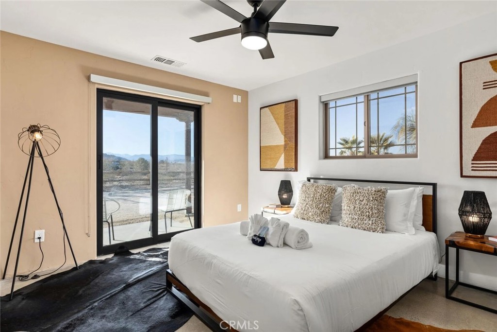7030 Mile Square Road Joshua Tree, CA 92252 - Photo 28 of 58 a bedroom with a bed and a large window