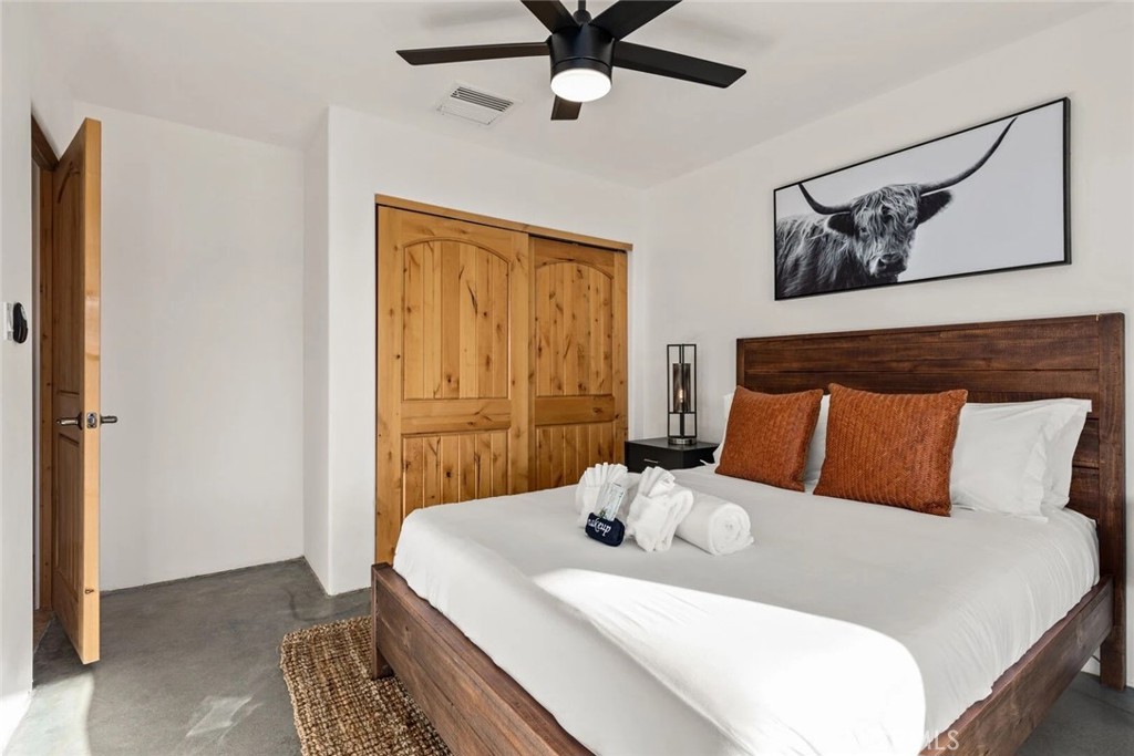 7030 Mile Square Road Joshua Tree, CA 92252 - Photo 34 of 58 a bedroom with a bed and ceiling fan