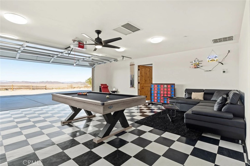 7030 Mile Square Road Joshua Tree, CA 92252 - Photo 38 of 58 a living room with a black white checkered floor with couches chair and a coffee table