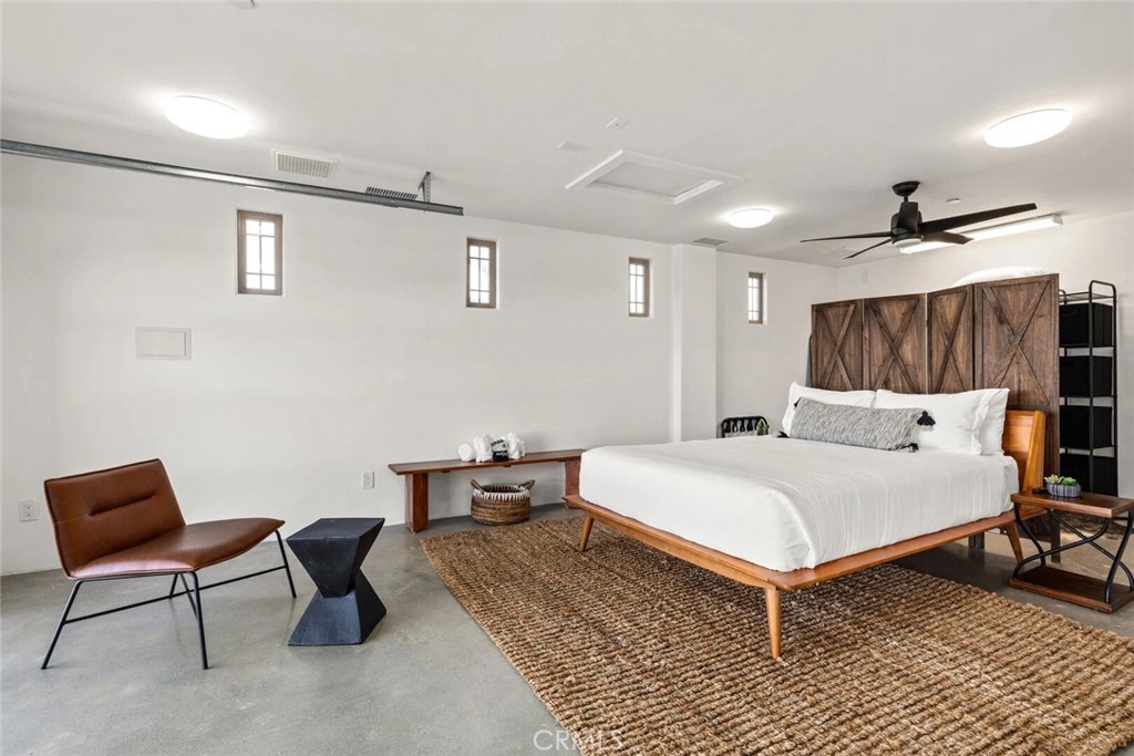 7030 Mile Square Road Joshua Tree, CA 92252 - Photo 43 of 58 a bed room with a bed and a chair