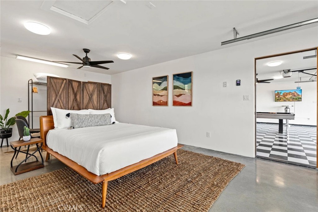 7030 Mile Square Road Joshua Tree, CA 92252 - Photo 44 of 58 a bedroom with a bed and a chandelier