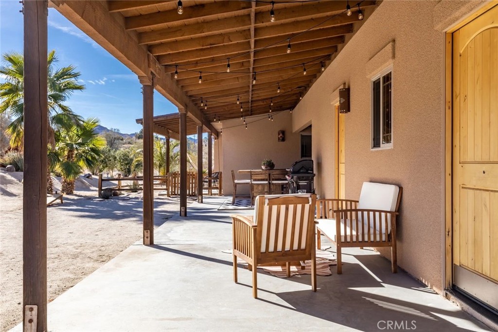 7030 Mile Square Road Joshua Tree, CA 92252 - Photo 46 of 58 a view of a porch with furniture and a yard