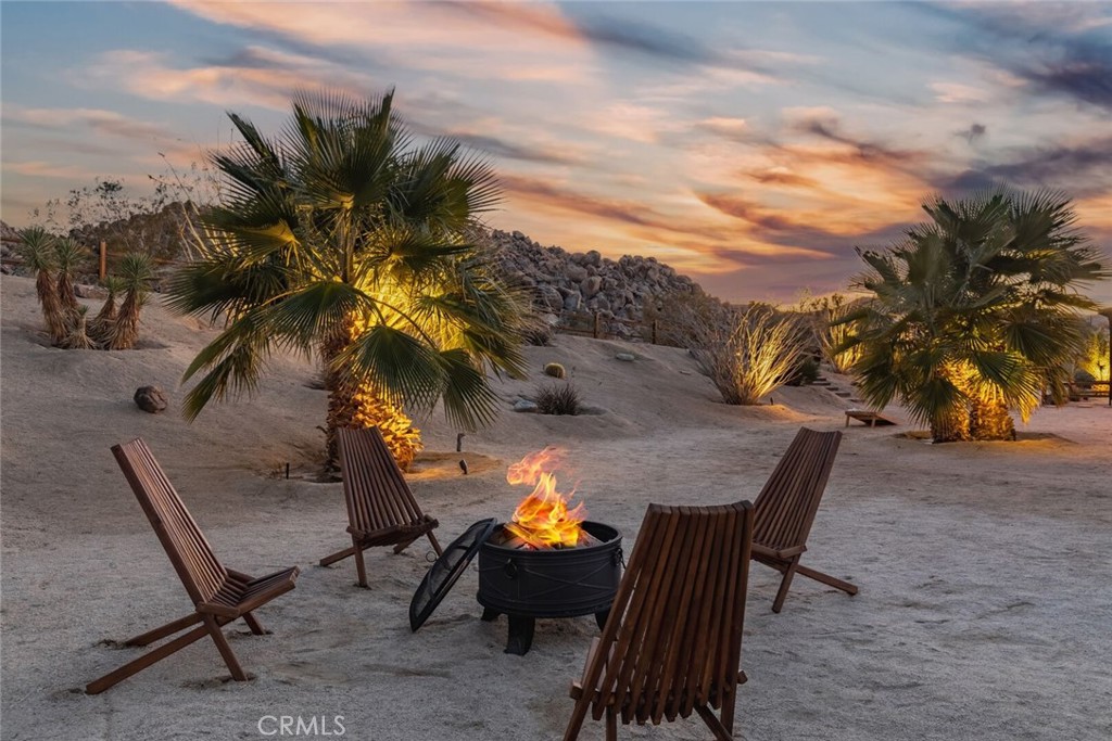 7030 Mile Square Road Joshua Tree, CA 92252 - Photo 49 of 58 a view of a backyard with furniture and a fire pit