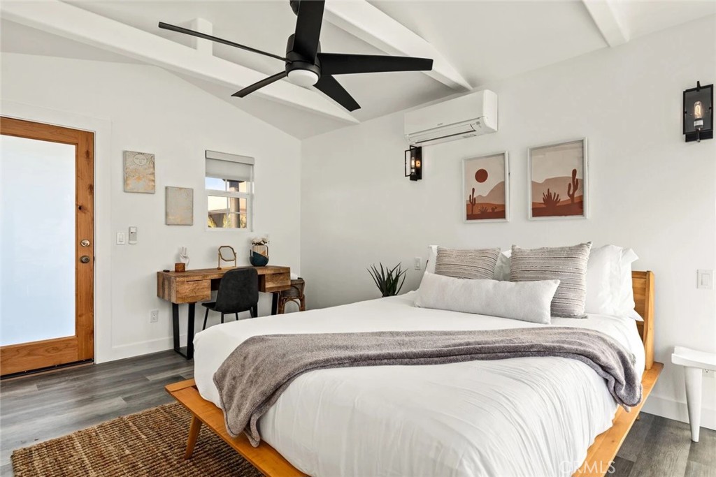 7030 Mile Square Road Joshua Tree, CA 92252 - Photo 55 of 58 a spacious bedroom with two beds and painting on the wall