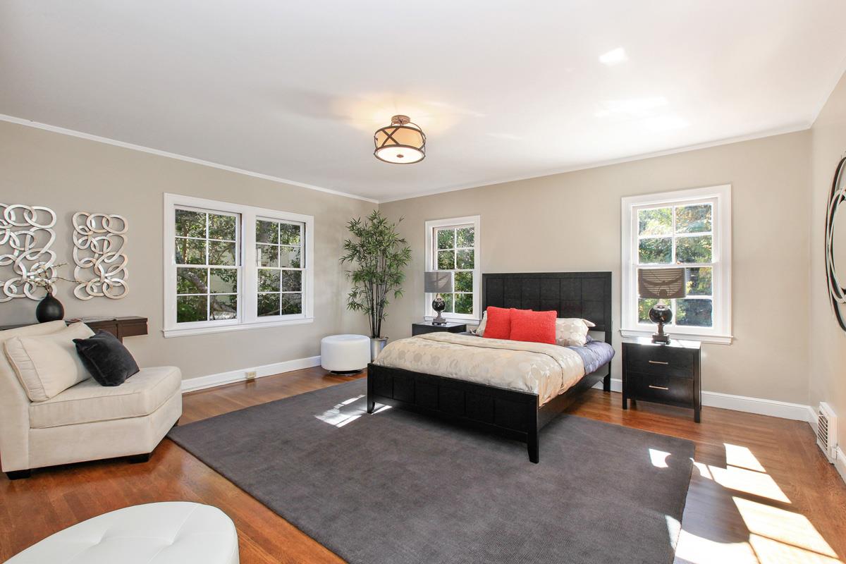 973 Baileyana Road Hillsborough, CA 94010 - Photo 24 of 35 a spacious bedroom with a bed a couch and a large window