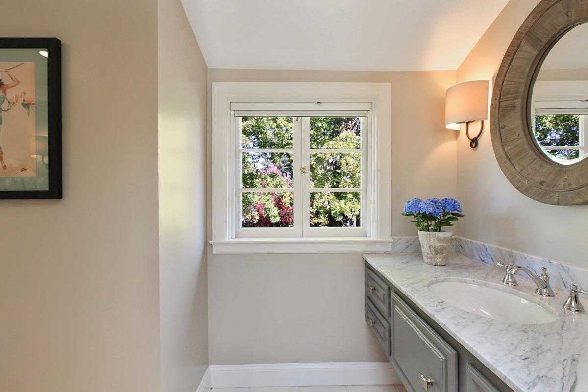 973 Baileyana Road Hillsborough, CA 94010 - Photo 25 of 35 a bathroom with a granite countertop sink and a mirror