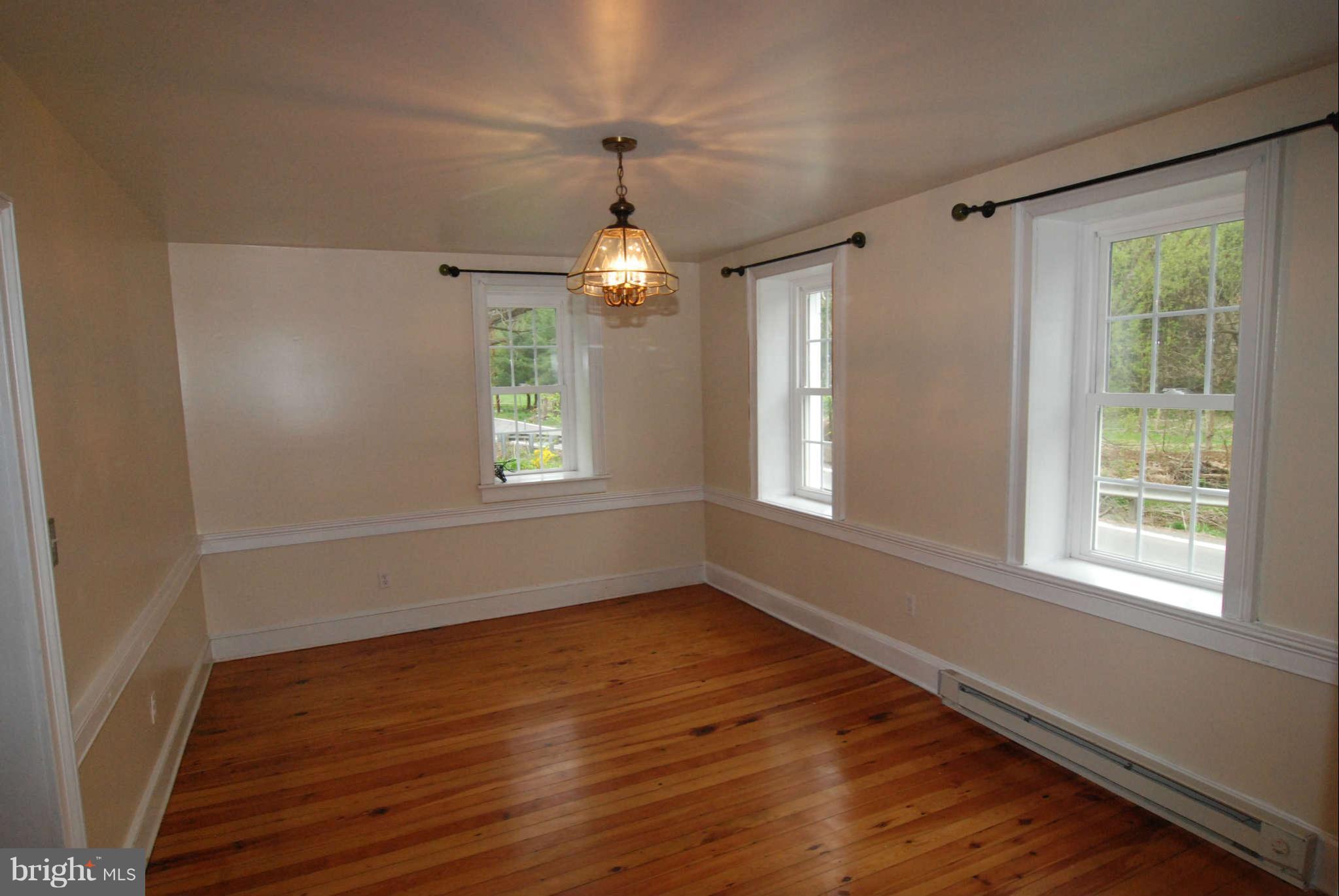 12516 Big Pool Road Clear Spring, MD 21722 - Photo 19 of 30 a big room with wooden floor a chandelier fan and windows