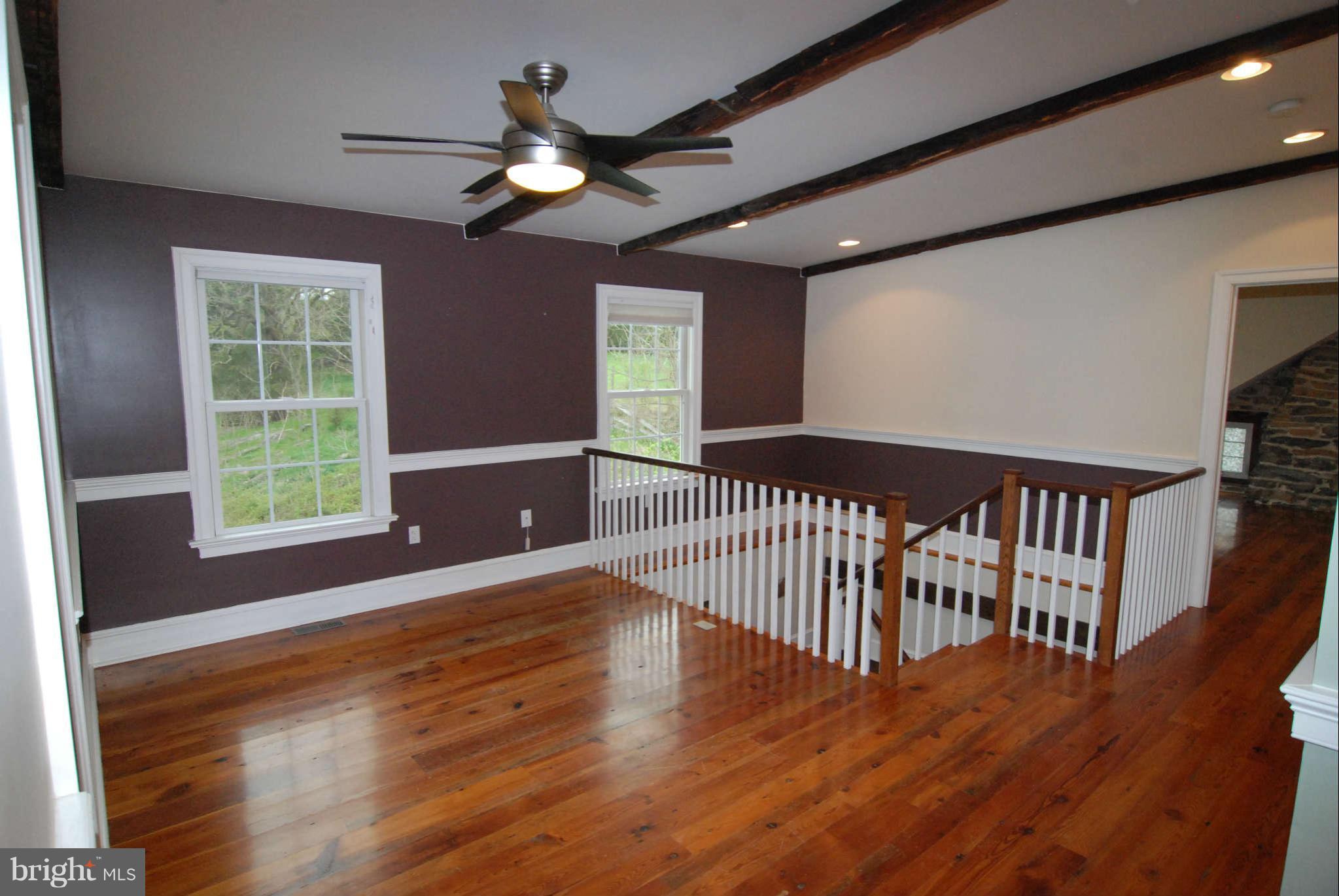 12516 Big Pool Road Clear Spring, MD 21722 - Photo 21 of 30 a view of a hallway with wooden floor and a ceiling fan