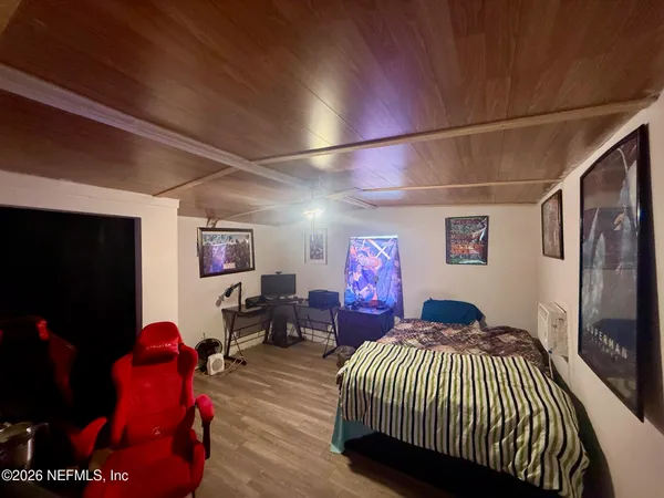 a bedroom with furniture and a flat screen tv