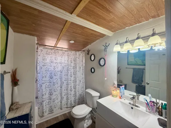 a bathroom with a sink toilet vanity and shower