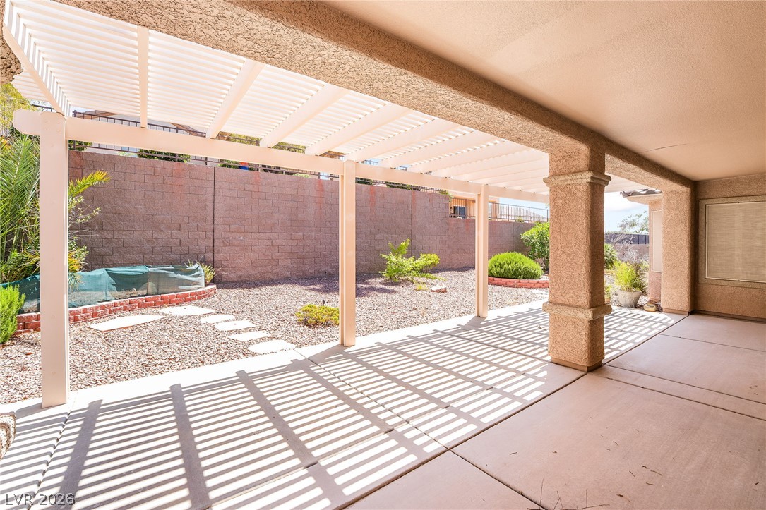 3033 Hartsville Road Henderson, NV 89052 - Photo 37 of 41 The expansive covered patio extends to a sun-drenched pergola, ideal for outdoor leisure.