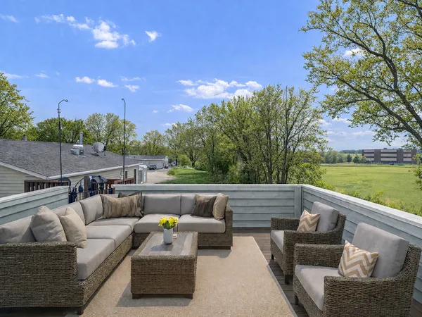 a roof deck with couches and potted plants