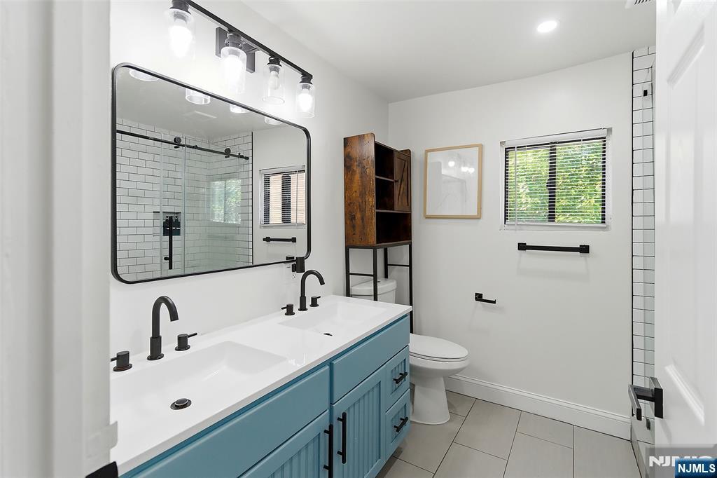 22 8th Avenue Newark, NJ 07104 - Photo 20 of 26 a bathroom with a double vanity sink toilet and mirror