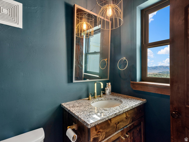 1225 Old Oregon Road Soda Springs, ID 83276 - Photo 5 of 67 Powder room featuring a wood-finish vanity with a granite countertop and an undermount sink