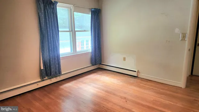 an empty room with wooden floor and closet