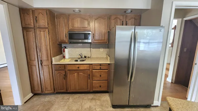a kitchen with stainless steel appliances granite countertop a refrigerator and a stove top oven