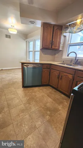 a kitchen with granite countertop a stove a sink and a refrigerator