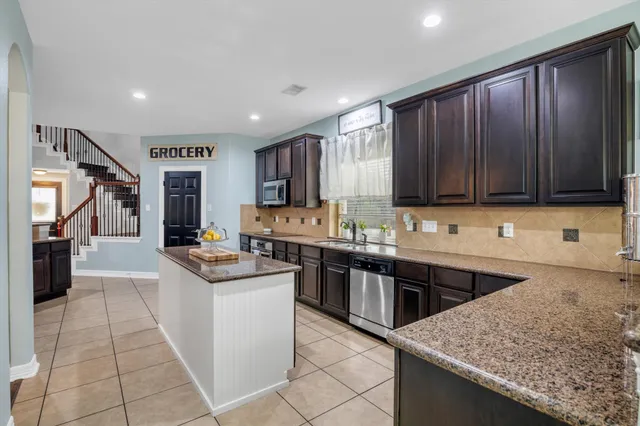a kitchen with lots of counter top space appliances and cabinets