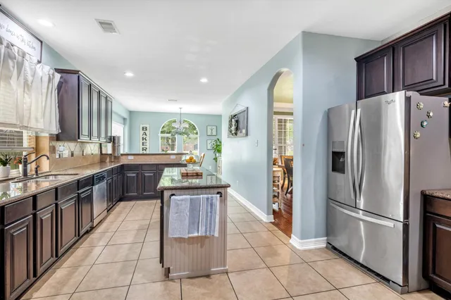 a kitchen with stainless steel appliances granite countertop a refrigerator and a stove