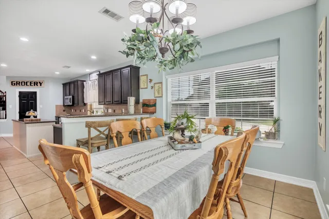 a view of a dining room and livingroom with furniture wooden floor and a chandelier