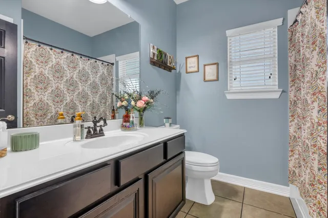 a bathroom with a sink a toilet and a large mirror