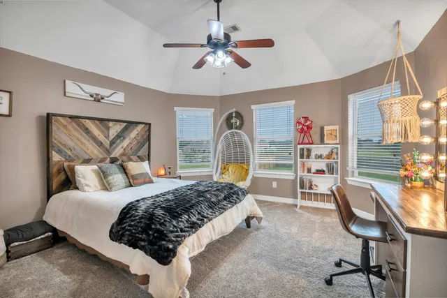 a bedroom with a bed a desk and chair with the bookshelf