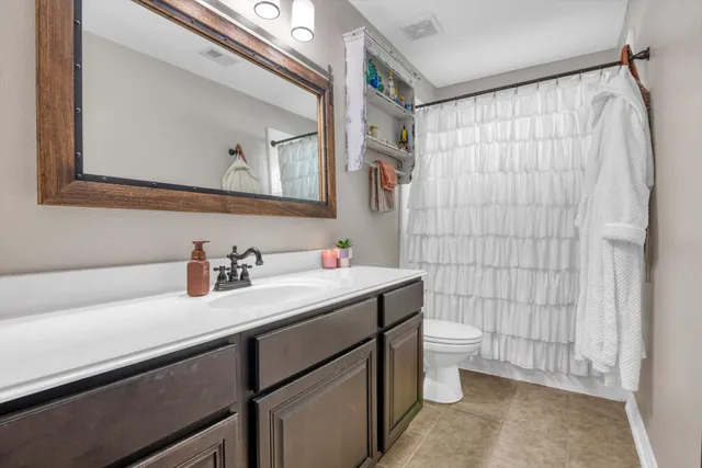 a bathroom with a sink vanity mirror and toilet