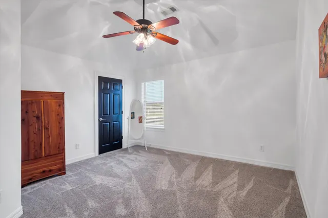 an empty room with closet and fan