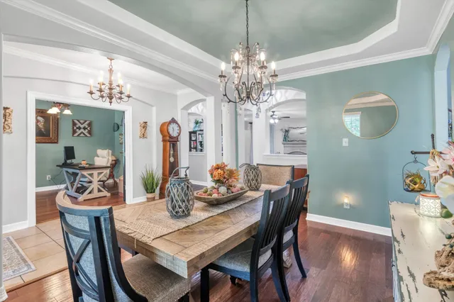 a dining room with furniture a chandelier and wooden floor
