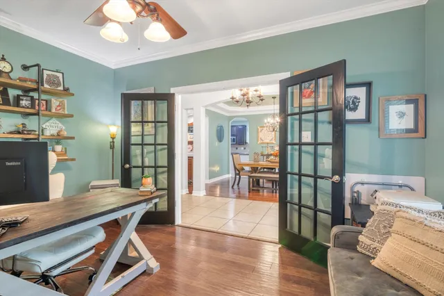 a dining room with wooden floor and chandelier