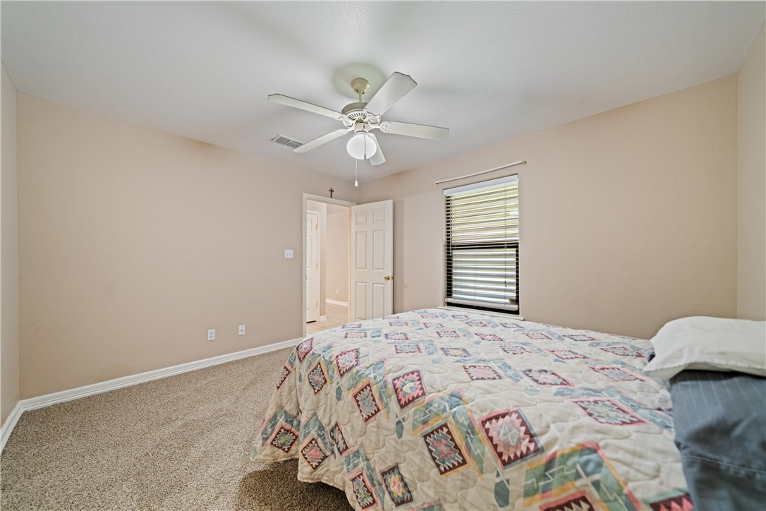 2839 McKinzie Road, Unit 10 Corpus Christi, TX 78410 - Photo 16 of 22 a bedroom with a bed and a chandelier