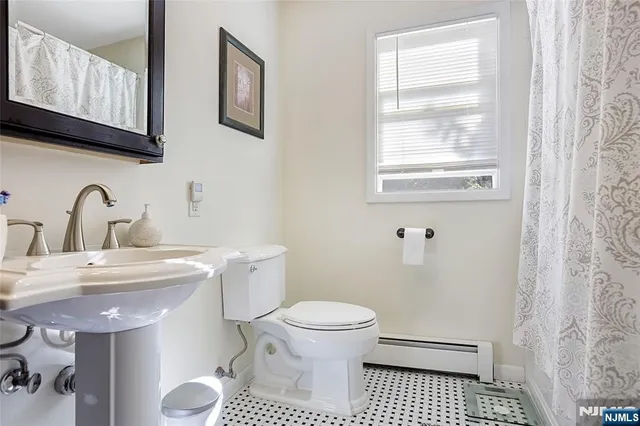 a bathroom with a sink toilet and a window