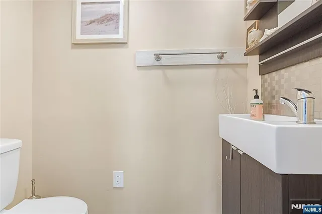 a bathroom with a sink mirror and toilet