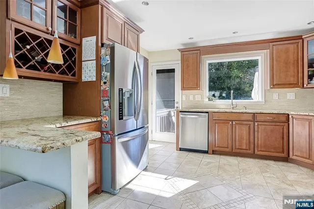 a kitchen with stainless steel appliances granite countertop a stove a sink and a refrigerator