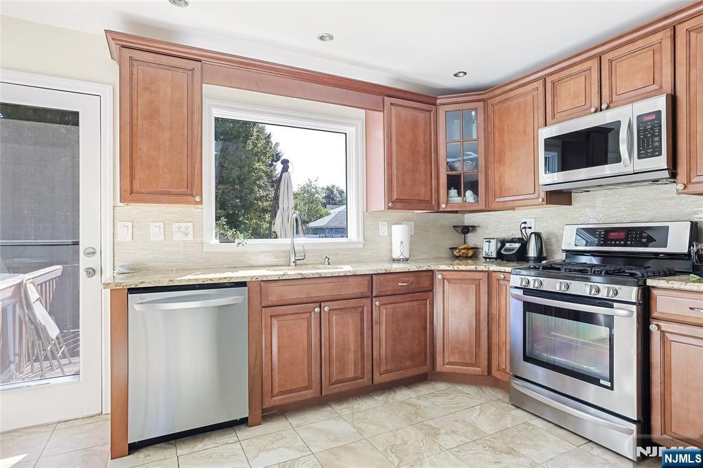 193 Prospect Place Rutherford, NJ 07070 - Photo 6 of 37 a kitchen with stainless steel appliances granite countertop a stove sink and microwave
