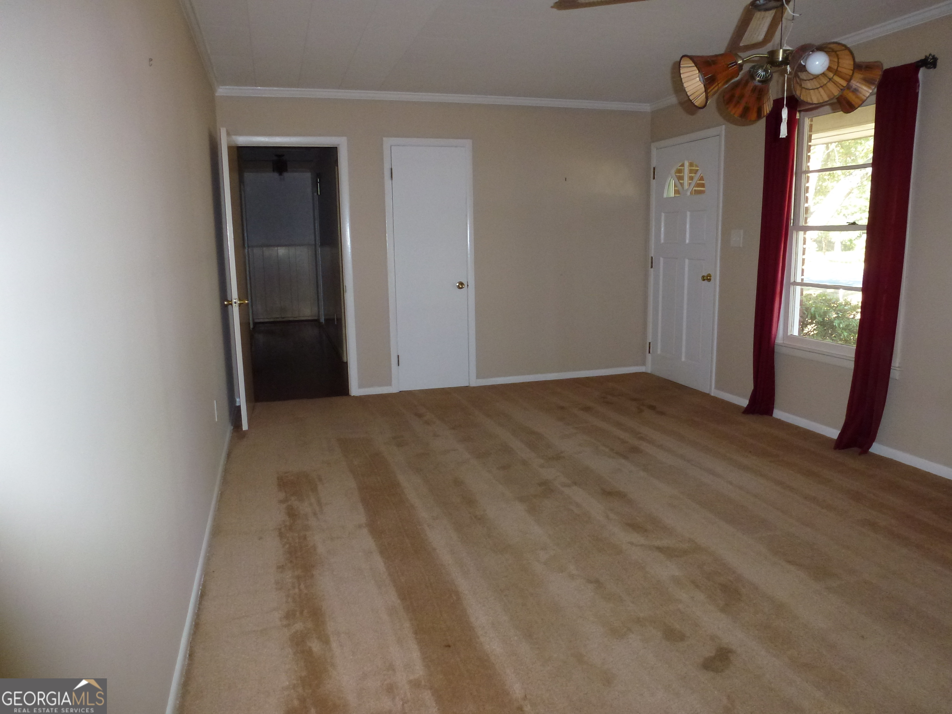 606 Park Avenue Claxton, GA 30417 - Photo 15 of 38 an empty room with windows and wooden door