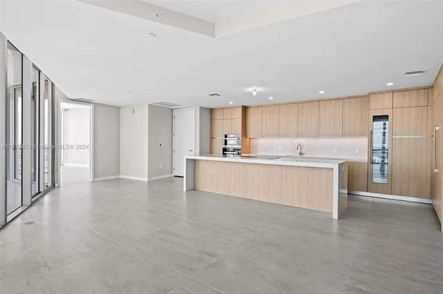 a view of kitchen with kitchen island and stainless steel appliances