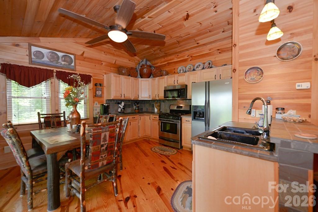 470 Bear Ridge Road Tuckasegee, NC 28783 - Photo 15 of 28 a kitchen with stainless steel appliances granite countertop a stove a refrigerator a kitchen island a sink and a refrigerator
